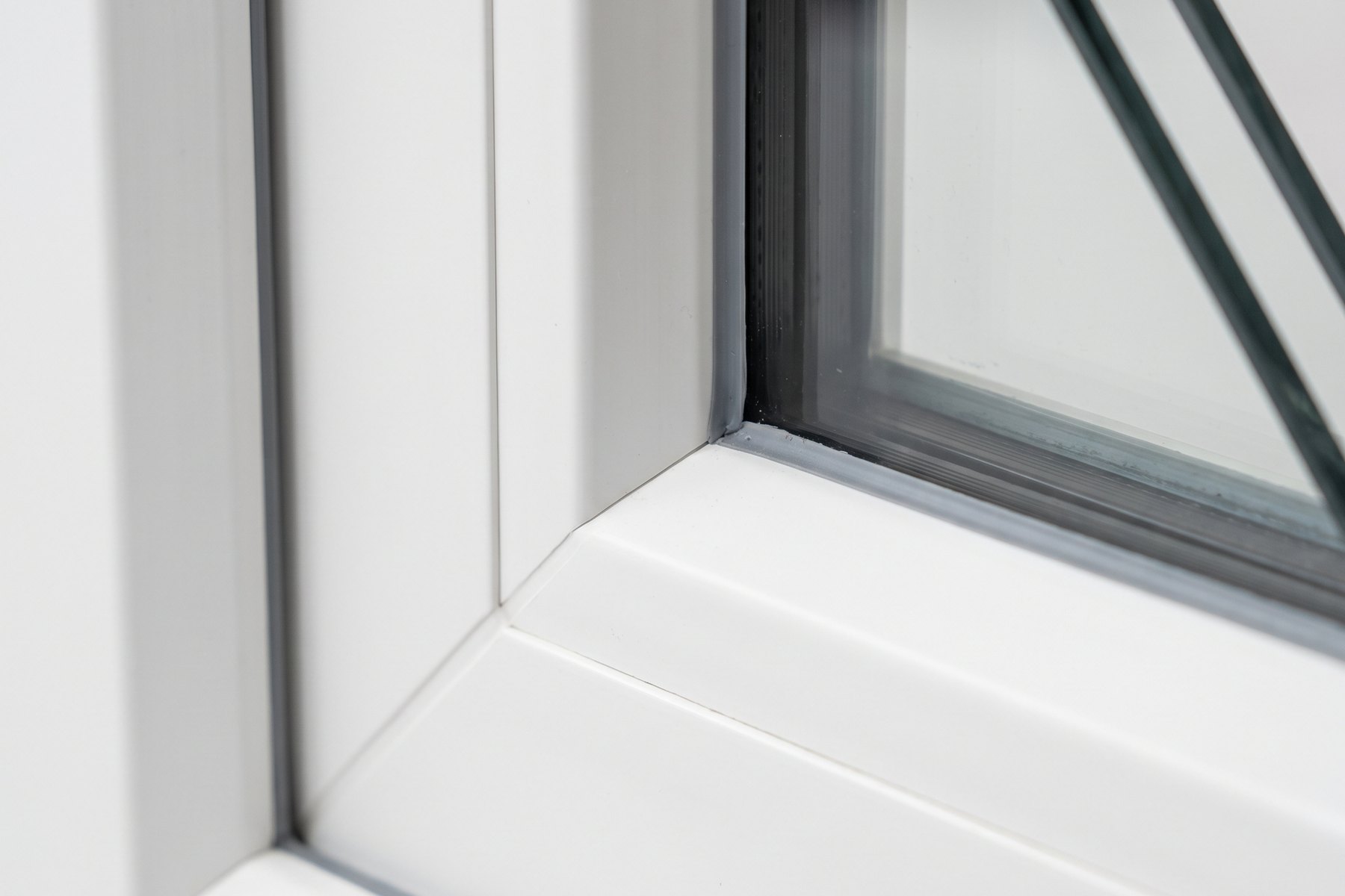 Hoek van een wit kunststof kozijn met glaspakket