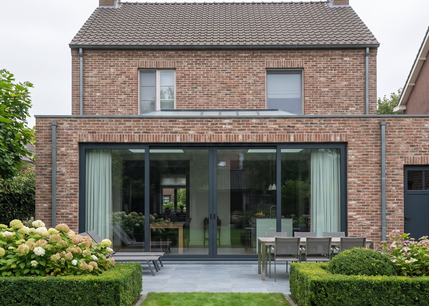 Dezelfde achtergevel met een brede kunststof schuifpui met grote glasvlakken